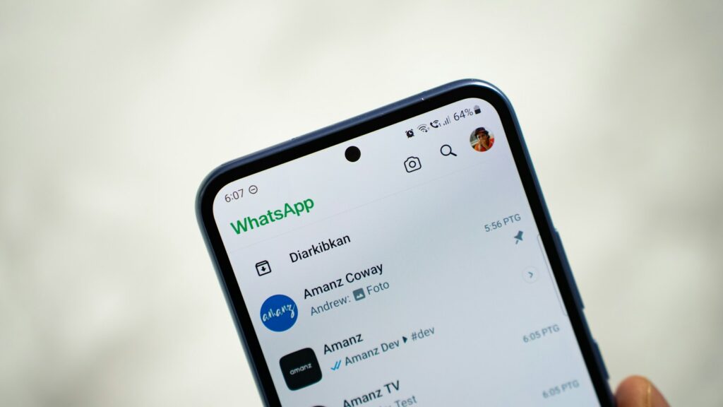 Pessoa segurando um celular com o WhatsApp aberto